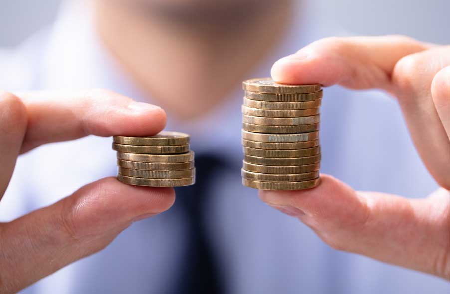 investor comparing two stacks of gold coin