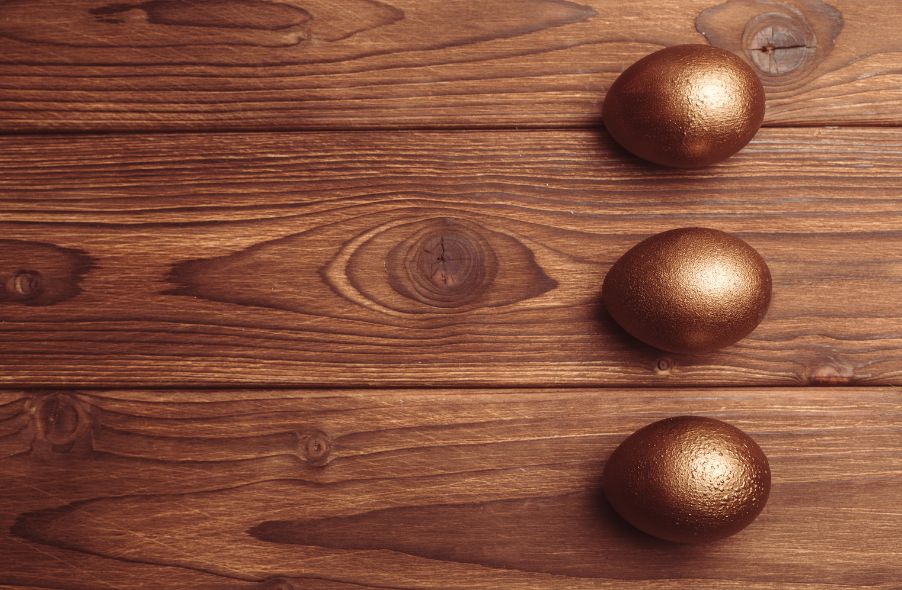 three golden eggs in wooden background